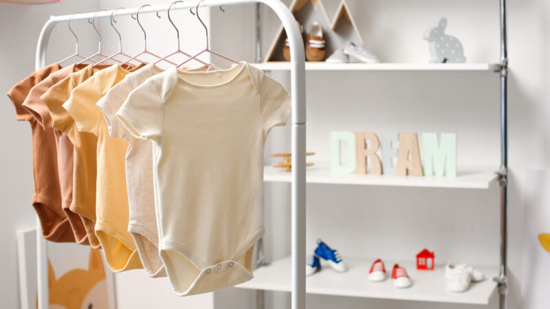 Rack with baby bodysuits in light children's room